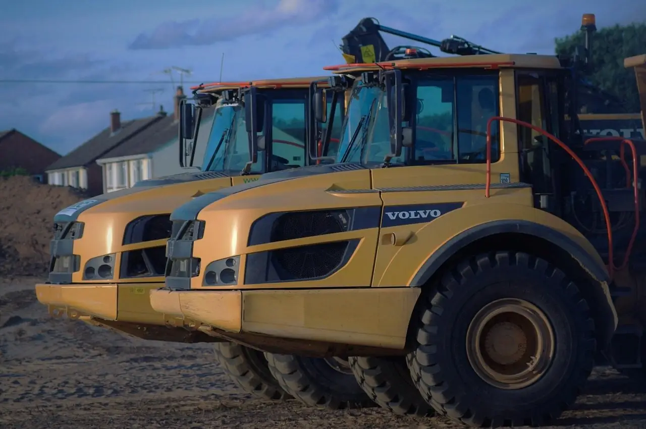 Two yellow articulated dump trucks parked side by side